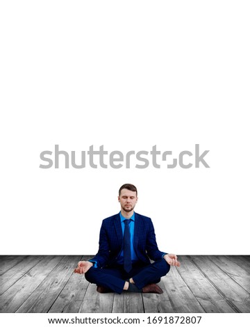 Calm businessman sitting in lotus pose and meditating. Over white wall background.
