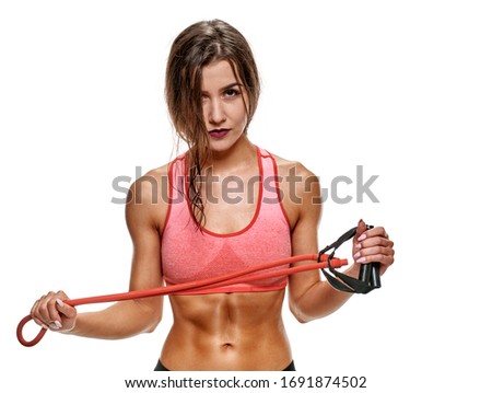 Portrait of beautiful healthy muscular woman training with elastic expander