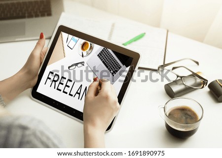 Young creative businesswoman working on digital tablet at home, female freelance