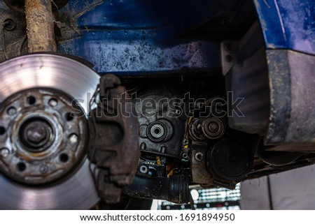 Car brake disc closeup on car service lifted for replacement