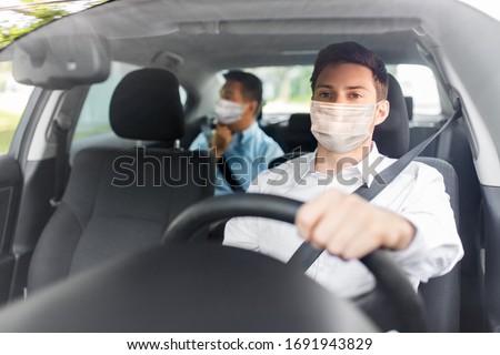 health protection, safety and pandemic concept - male taxi driver wearing face protective medical mask driving car with passenger Royalty-Free Stock Photo #1691943829