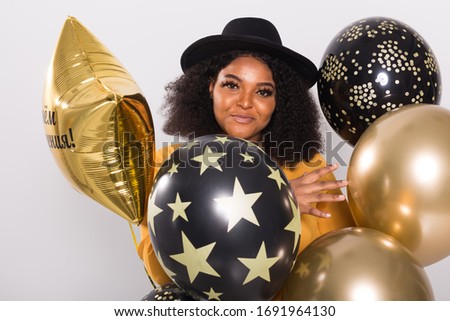 Holidays, birthday party and fun concept - Portrait of smiling young African-American young woman looking stylish on white background holding balloons.