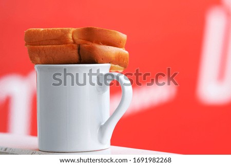cup of coffee and bread on wood counter background and space for text