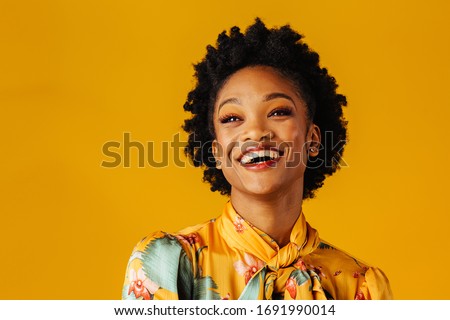 Portrait of a very happy and excited young woman smiling and looking up in an elegant floral top