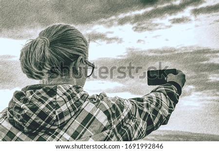 Portrait of woman taking a picture at the beautiful mountains background.  Dashed pencil sketch effect. 