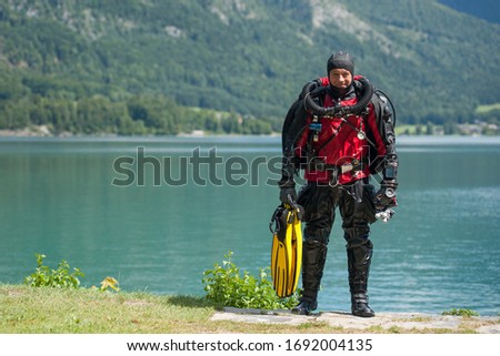 Scuba diver with rebreather and dry suit just after the dive in deep lake Royalty-Free Stock Photo #1692004135