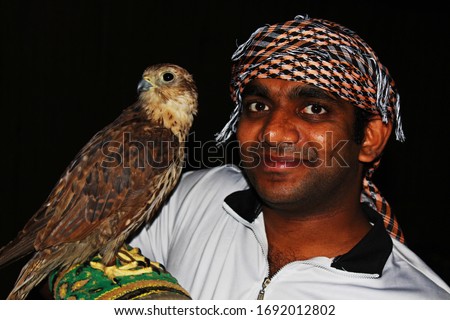 young gentile man with falcon bird at night in arabia