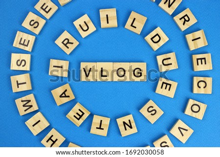 Vlog word wooden cubes on blue background