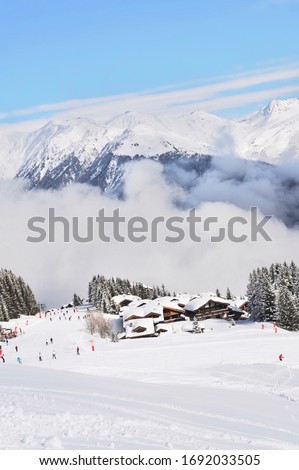 Winter scenery beautiful ski resort with chalets and skiing people 