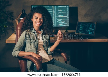 Portrait of positive skilled afro american girl web designer engineer sit chair enjoy her night company data work hold glasses in workplace workstation Royalty-Free Stock Photo #1692056791