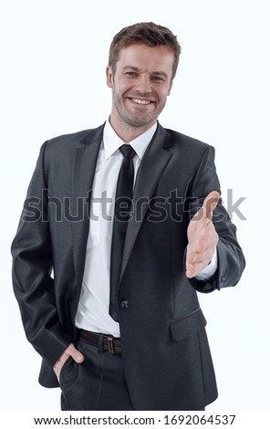 handsome businessman holds out his hand for a handshake.