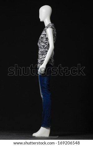 full-length side view mannequin female dressed in fashion shirt and jeans on black background 