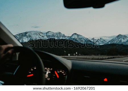 
view from a car on the snowy mountains of the Alps at sunset in summer Germany