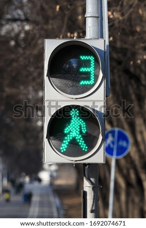 Green signal at the traffic light for pedestrians. Pedestrian traffic is allowed.