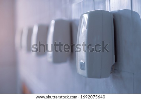 Hand dryer. A row of automatic hand dryers hang on a wall.Shallow depth of field