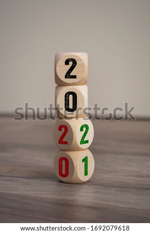Tower made of cubes and dice with 2020 and 2021 on wooden background Royalty-Free Stock Photo #1692079618