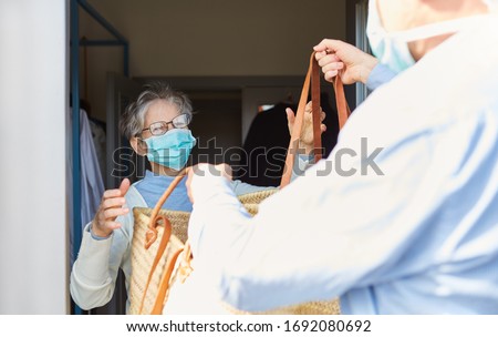Grocery shopping as a delivery service for quarantined seniors at the Covid-19 Coronavirus epidemic Royalty-Free Stock Photo #1692080692