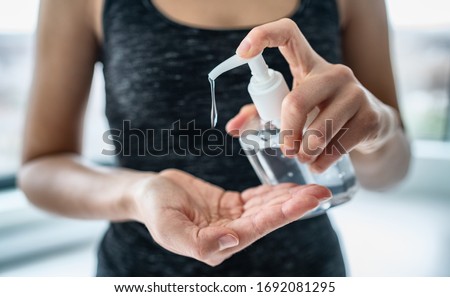 Hand sanitizer woman applying sanitizing gel liquid rubbing hands clean personal hygiene coronavirus pervention at home. Sanitiser bottle. Royalty-Free Stock Photo #1692081295