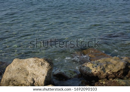 Clear sea water washing off coastal boulders