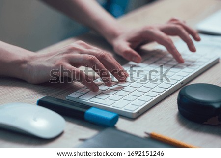 Hands of a young woman typing on a white keyboard stock photo