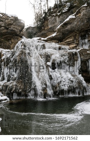 Icy waterfall with icicles in winter (frozen water).