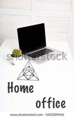 Home office. Laptop with a blank screen on a white table with a mouse. Home or office interior background. Close-up of laptop keyboard