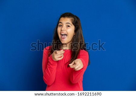 Adorable preteen girl with red t-shirt i on a blue background