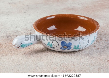 Antique pottery ladle on concrete background. Copy space for text