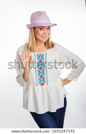 Isolated portrait of a smiling girl in a purple hat. Young beautiful girl shows five. Beautiful woman waves her hand.
