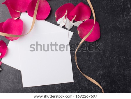 red rose petals with a raffia ribbon and a blank note card make a posh party invitation