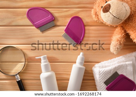 Treatment and prevention for children's hair against lice with products and accessories on a wood table. Horizontal composition. Top view