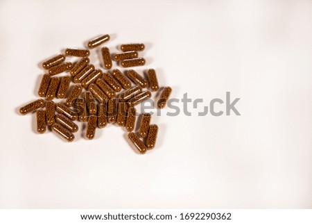 Herb capsule with Brown herbal leaf. Pills in a white background. Copy space