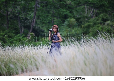 A female photographer taking pictures in grass color white, Thailand