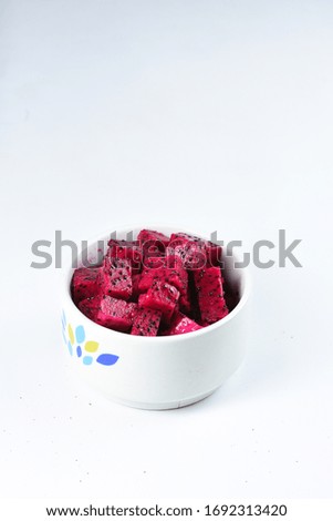 Cubes of fresh red Dragon fruit or Ripe Pitahaya/pitaya fruit in white bowl isolated white background