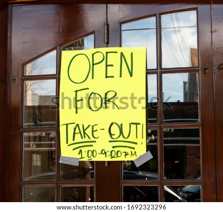 Open for take out only sign posted on the windows of a restaurant in Babylon Village New York USA because of the coronavirus COVID-19 pandemic. Royalty-Free Stock Photo #1692323296