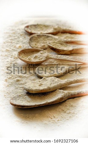 Many wooden spoons sprinkled with wheat flour. Baking concept on flour background. Photo filter effect, HDR. Top view.