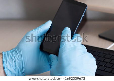 a phone in hand, in protective gloves