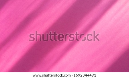 Diagonal shadows on pastel pink paper. Abstract backgorund. Stock photo.