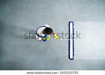 Man With Mop And Wet Floor Sign