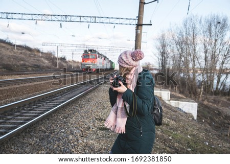 The girl is taking photo of railways with locomotive