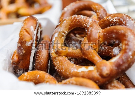 Bavarian delicious freshly baked and freshly prepared homemade soft pretzel lying among pretzels, in the background a different gravy. Close up pretzel salt selective focus Royalty-Free Stock Photo #1692385399