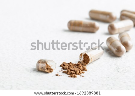 open capsule with Peruvian Maca on a white background  Royalty-Free Stock Photo #1692389881