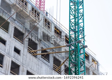 The supports and fastenings supporting the construction crane are installed on the wall of the building and at the windows