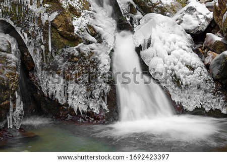 Ice covered creek and waterfall with icicles