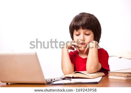 child in red t-shirt reading a textbook