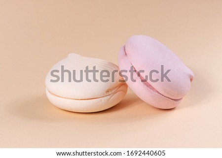 Delicious marshmallows in pastel colors on a beige background