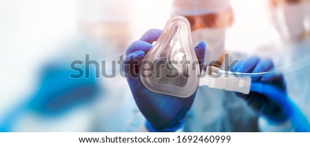 Doctor puts on oxygen mask. Emeregency and first aid concept. Royalty-Free Stock Photo #1692460999