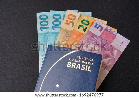 Translation: Federative Republic of Brazil. Mercosur passport. /  Brazilian passport and Brazilian money. Travel concept.