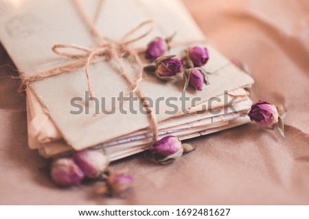 Laced love paper letters in stack with dry flowers closeup. Romantic memories concept.  Royalty-Free Stock Photo #1692481627