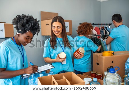 We are successful team of social workers. Group of people working on humanitarian aid project. Teamwork in homeless shelter. Small multi-ethnic group of people working on humanitarian aid project Royalty-Free Stock Photo #1692488659